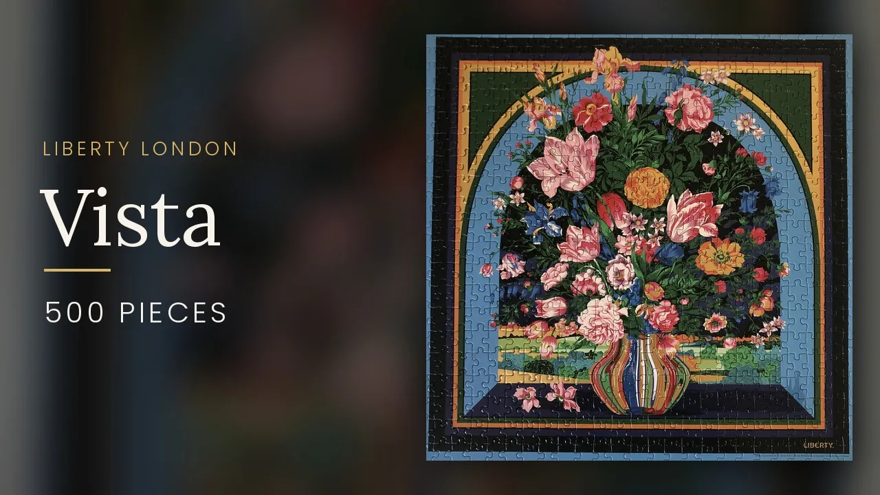 The finished Liberty London Vista puzzle, a dense floral print in blues and warm pinks with a striped vase at the center.